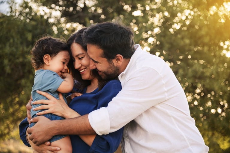 Happy family with parents and child hugging and smiling together